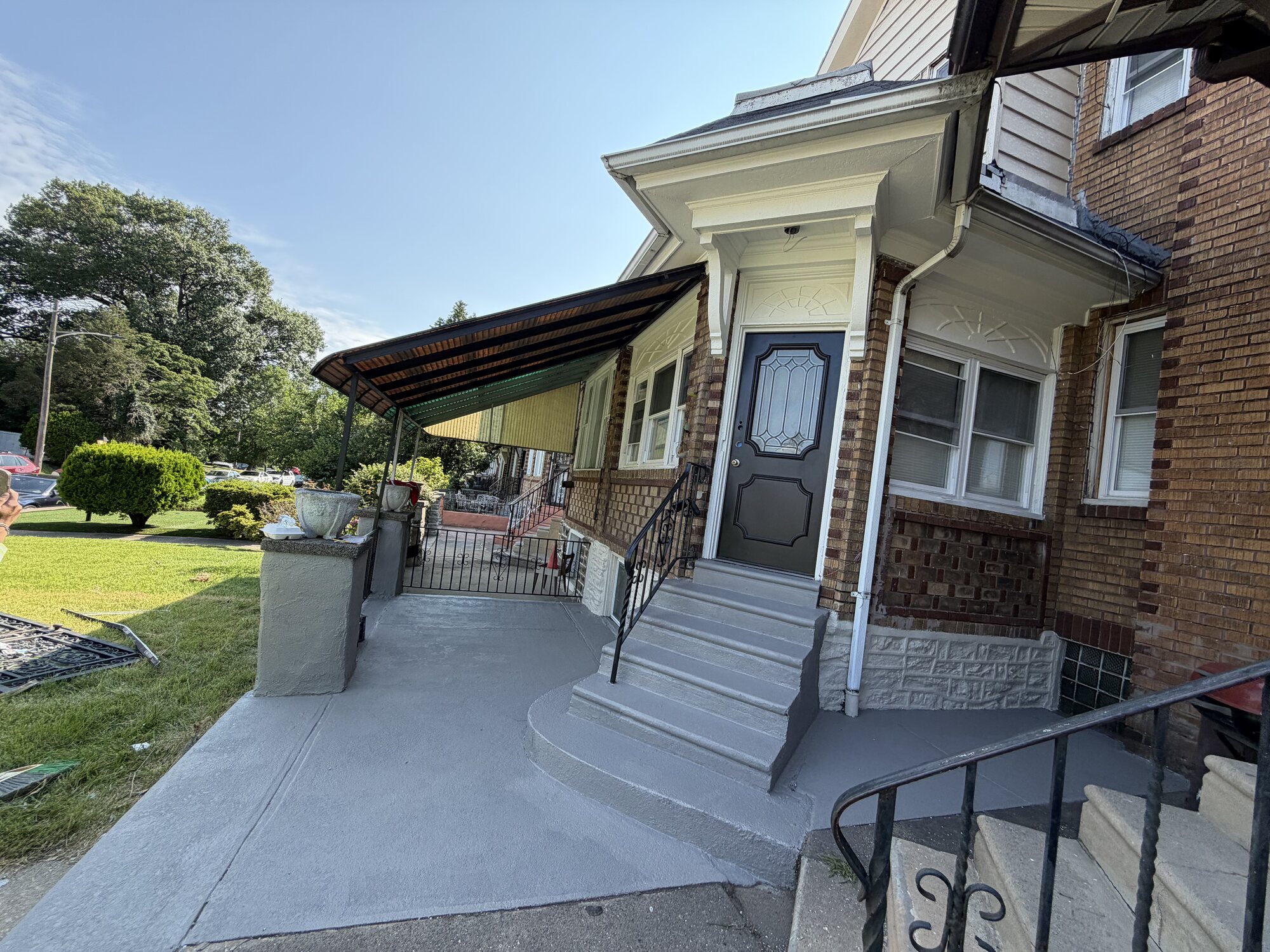 Finished grey porch steps and walkway on a Philadelphia brick home