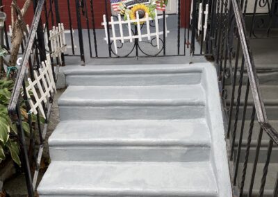 Painted porch steps and door on a Philadelphia home with red siding