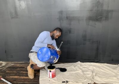 BB2M Gaming Studio in Philadelphia, PA: a UMAR Painting Co. painter cutting in a grey primed wall inside the Building Boys to Men gaming studio where a painting trades video game is being created.