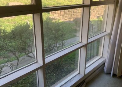 Freshly painted white picture window trim and baseboard in a Philadelphia living room