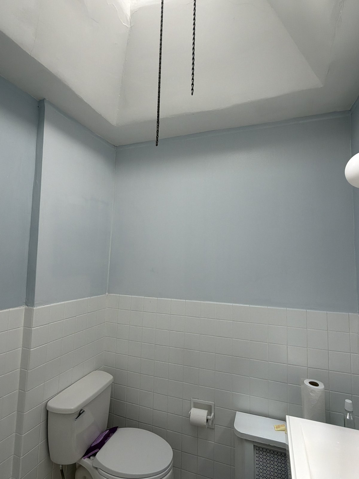After Bathroom Repair and Paint - Light Blue Walls Over White Tile, Philadelphia, PA | Affordable Philly Painters After photo of a repaired and repainted bathroom with smooth light blue walls and ceiling above white tile wainscot in a Philadelphia, PA rowhome, finished by UMAR Painting Co.