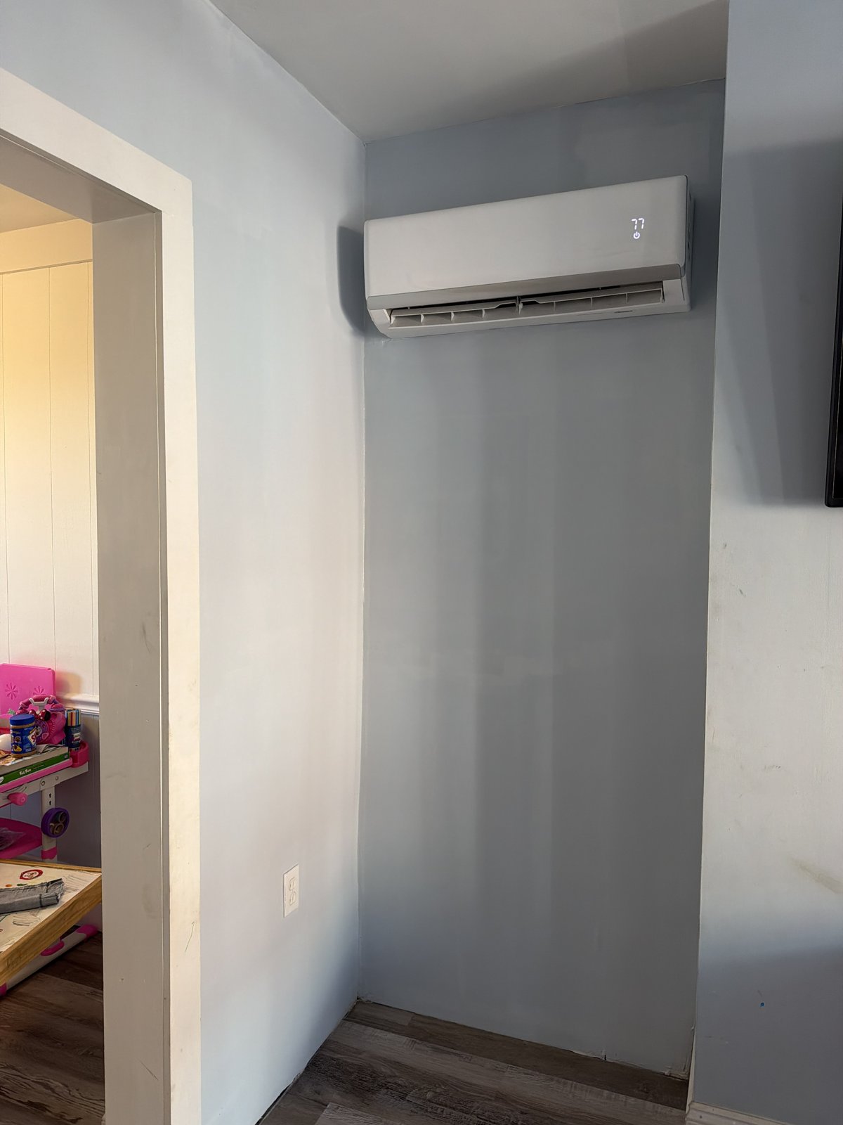After Wall Repair and Paint - Smooth Light Blue Walls Around Mini-Split, Philadelphia, PA | Affordable Philly Painters After photo of a repaired and freshly painted light blue wall with a wall-mounted mini-split and white trim in a Philadelphia, PA home, completed by UMAR Painting Co.
