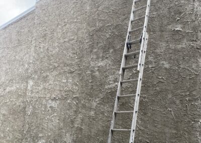 Exterior stucco wall prep with ladder in Philadelphia - Umar Painting Company